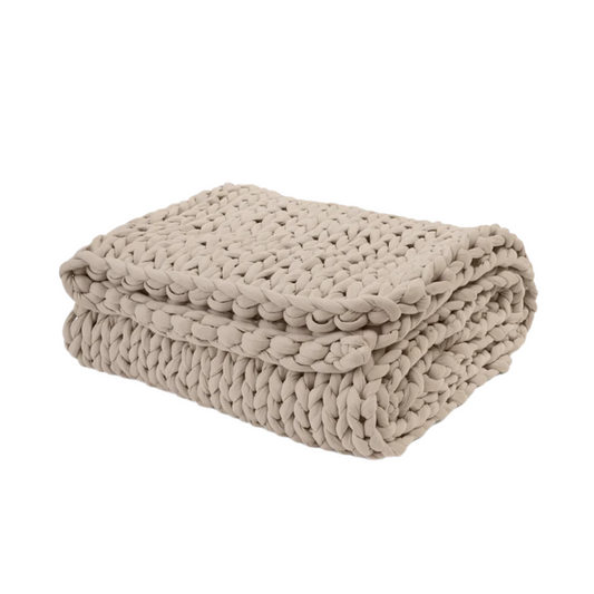 Folded beige blanket on a white background